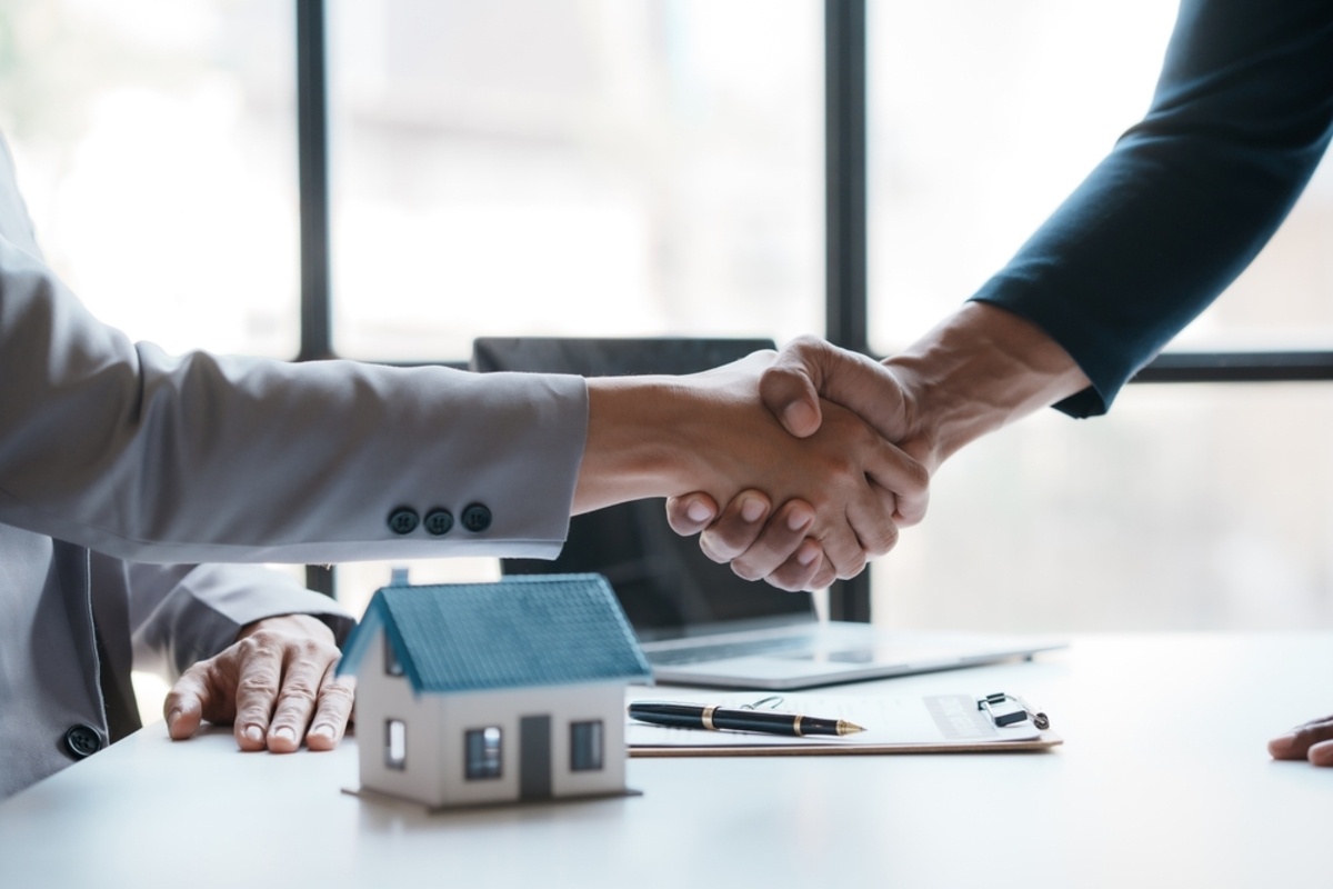 A real estate agent shakes hands with a client