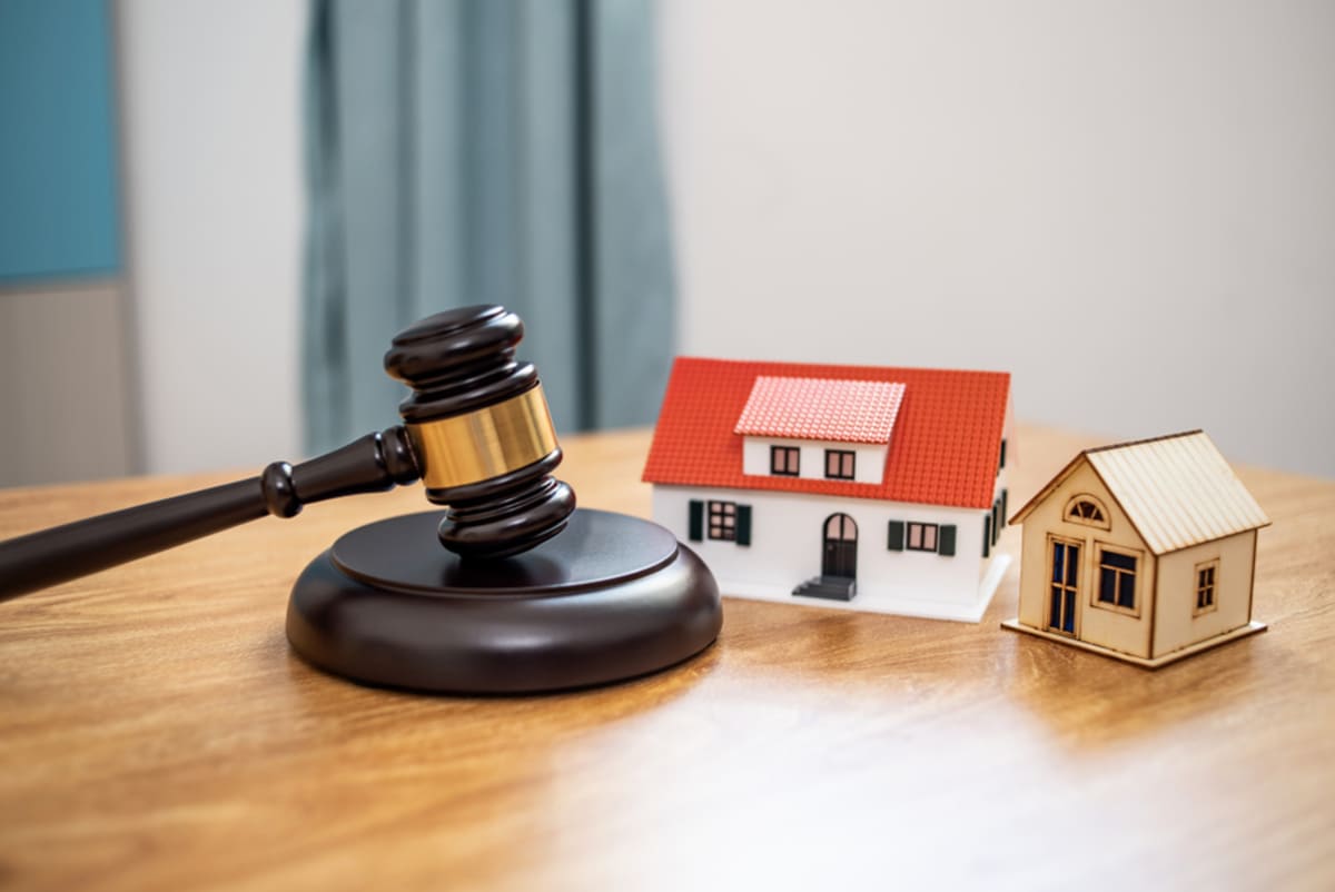 Gavel and small house on the table