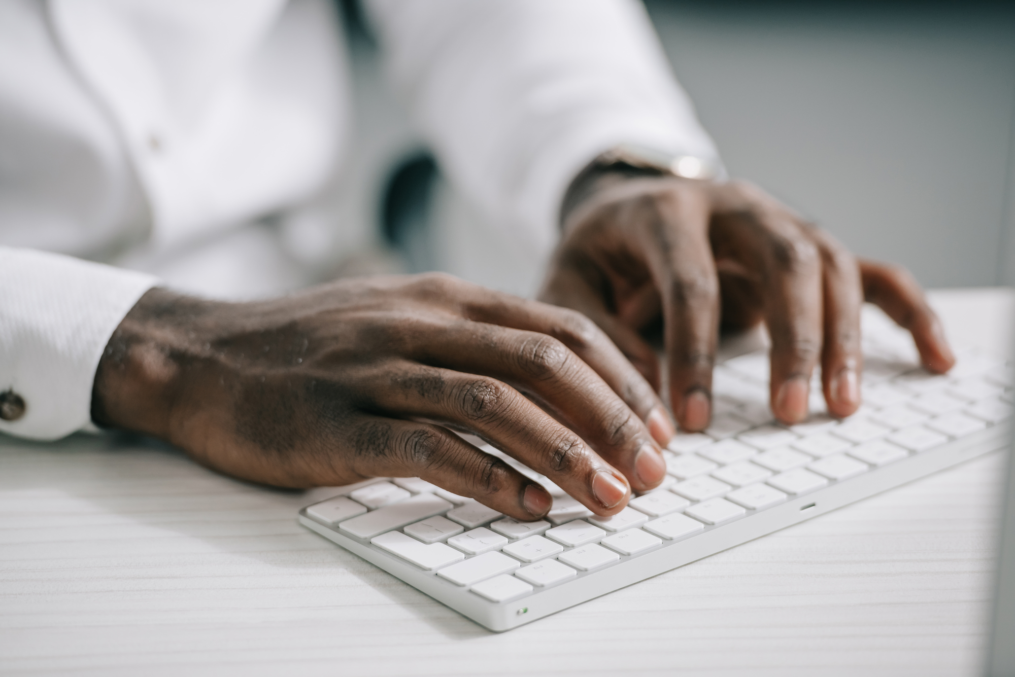 Cropped image of african american businessman typing on computer keyboard in office