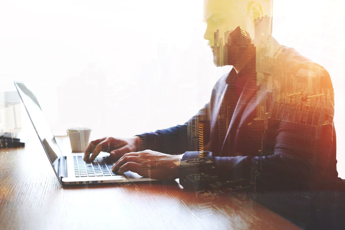 Double exposure of trader man dressed in corporate suit is analyzing housing market through laptop.