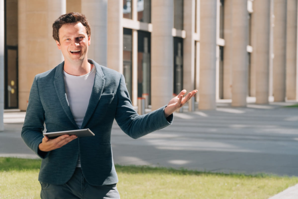 Residential real estate broker in front of a multi-family building